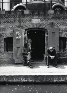 500702 Afbeelding van twee mannen van het slijp- en polijstbedrijfje Van Kasteel bij de werfkelder van het huis ...